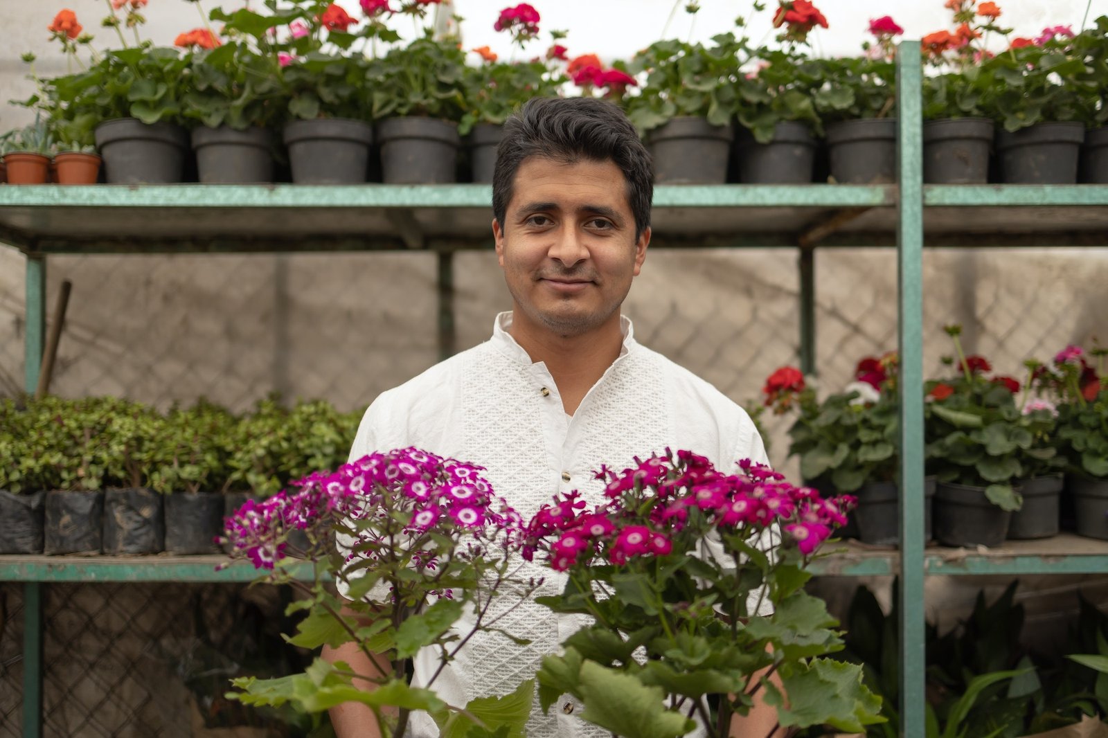 Friendly Hispanic male gardener in a nursery