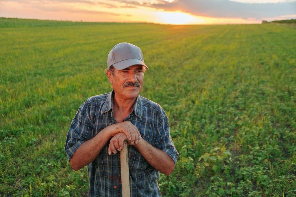 Portrait of a Cheerful male worker with mustache in agricultural farm. Sunlight